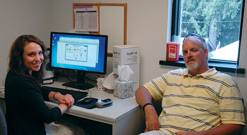 Two people sitting by a computer