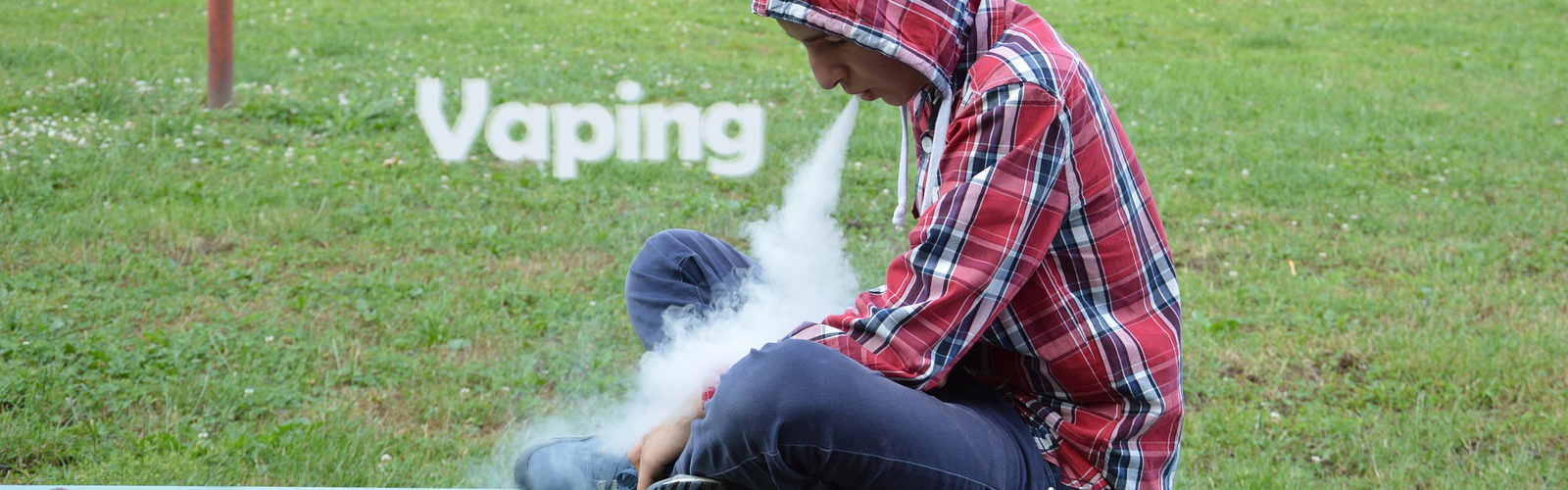 Man vaping on a park bench