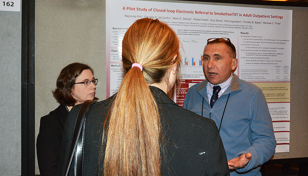 Mark Zehner (right) and UW-CTRI Associate Director of Research Dr. Danielle McCarthy (left) discuss their research with a fellow SRNT attendee. 