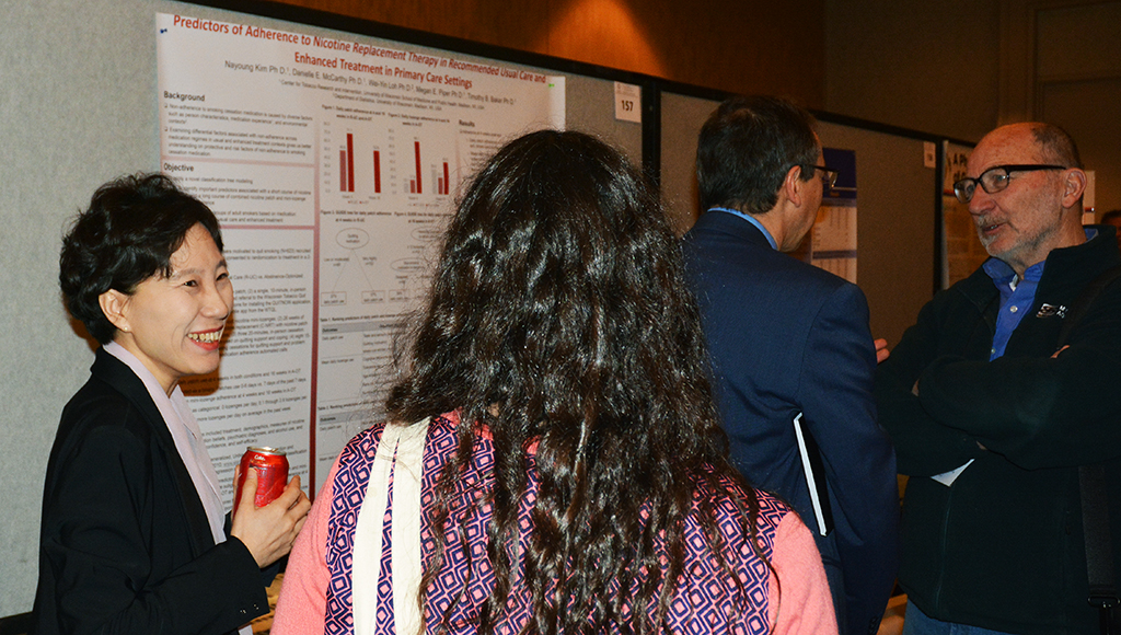 UW-CTRI Postdoctoral Research Associate Dr. Nayoung Kim (far left) discussed her research findings with several SRNT attendees. Kim presented three different posters. 