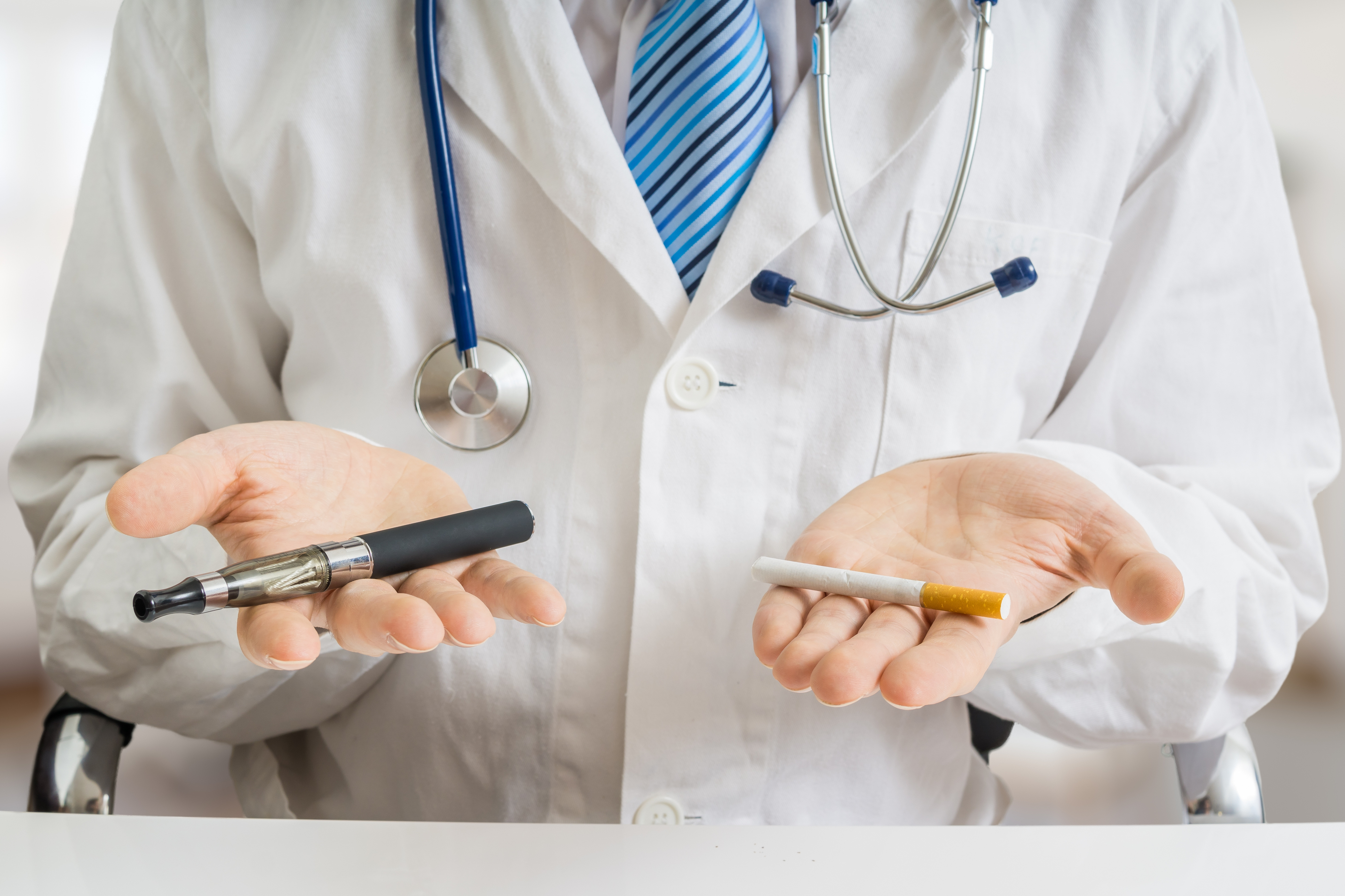 Doctor holds a cigarette and an electronic cigarette