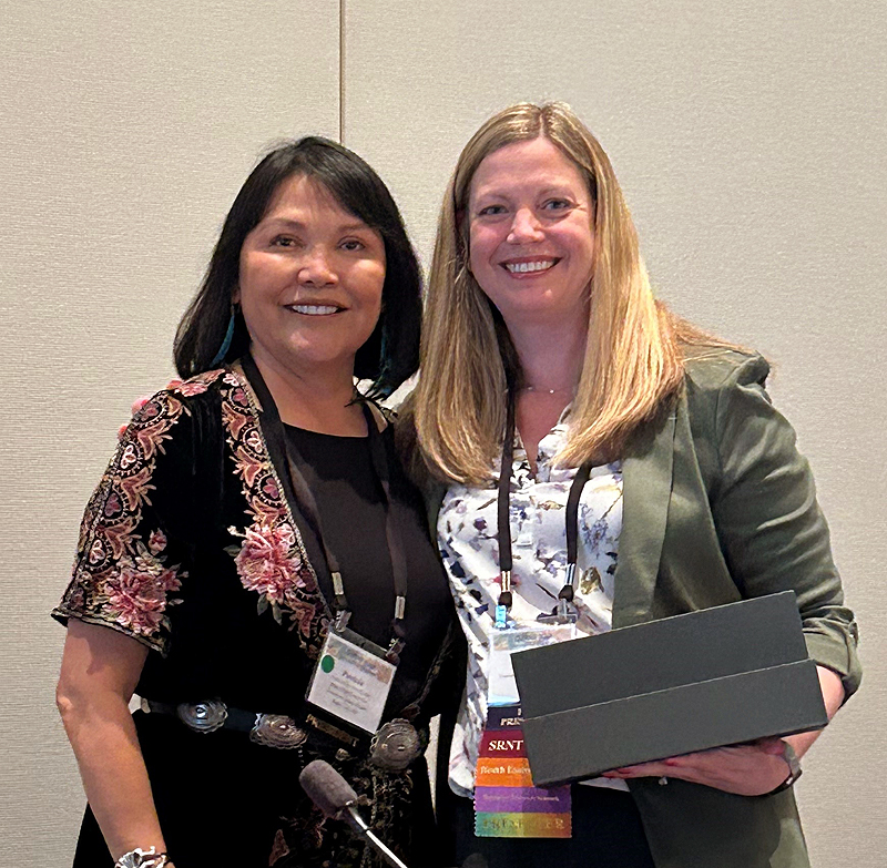 Dr. Patricia Nez Henderson, outgoing President of SRNT, hands crystal bookends to former SRNT President Dr. Megan Piper, as a thank you for her nine years of service to SRNT. 